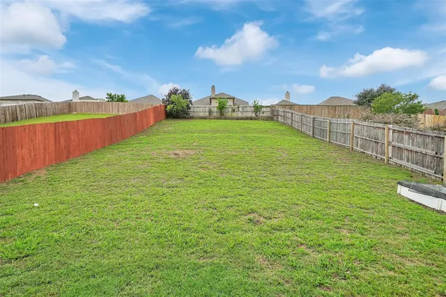 a view of a house with a big yard and large trees