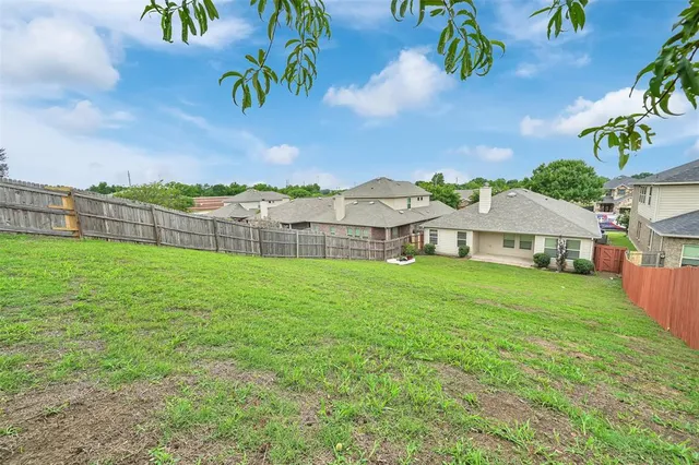 an aerial view of residential houses with outdoor space and trees
