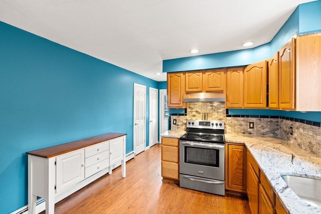 72 Beach Road Salisbury, MA 01952 - Photo 10 of 37 a kitchen with wooden floor and stainless steel appliances