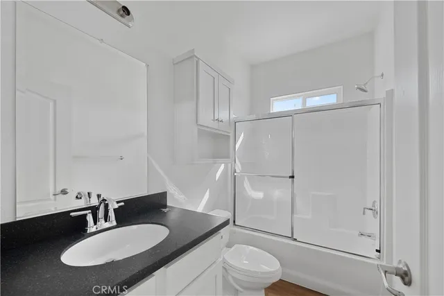 a bathroom with a sink toilet a mirror and shower