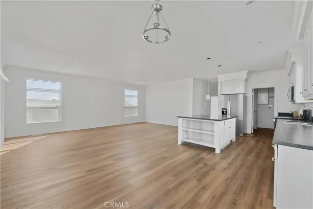 a view of kitchen and white cabinets with wooden floor