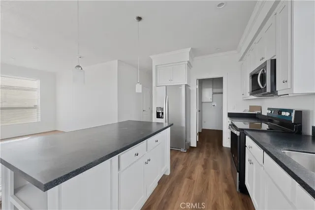 a kitchen with granite countertop a sink stove and refrigerator