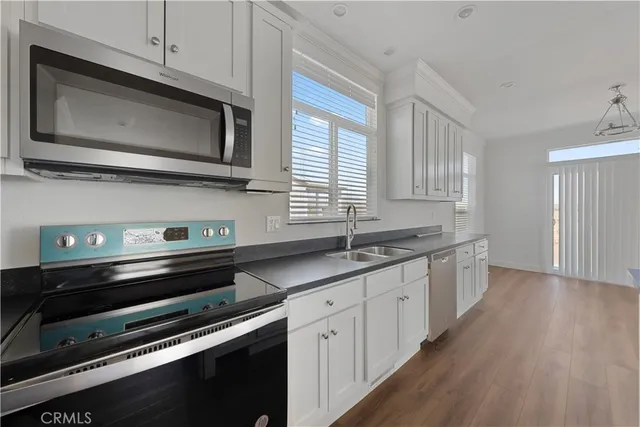 a kitchen with stainless steel appliances a stove microwave and sink