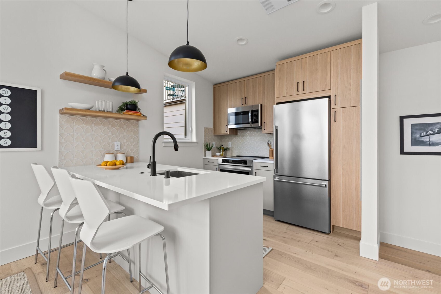 8407 42nd Avenue Southwest Seattle, WA 98136 - Photo 13 of 34 a kitchen with stainless steel appliances a refrigerator a sink a stove and white cabinets