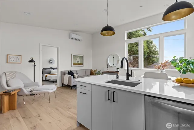a kitchen with a sink dishwasher a dining table and chairs with wooden floor