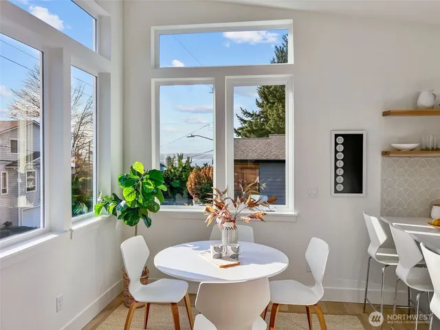 a dining room with furniture potted plants and wooden floor