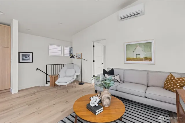 a living room with furniture potted plant and wooden floor