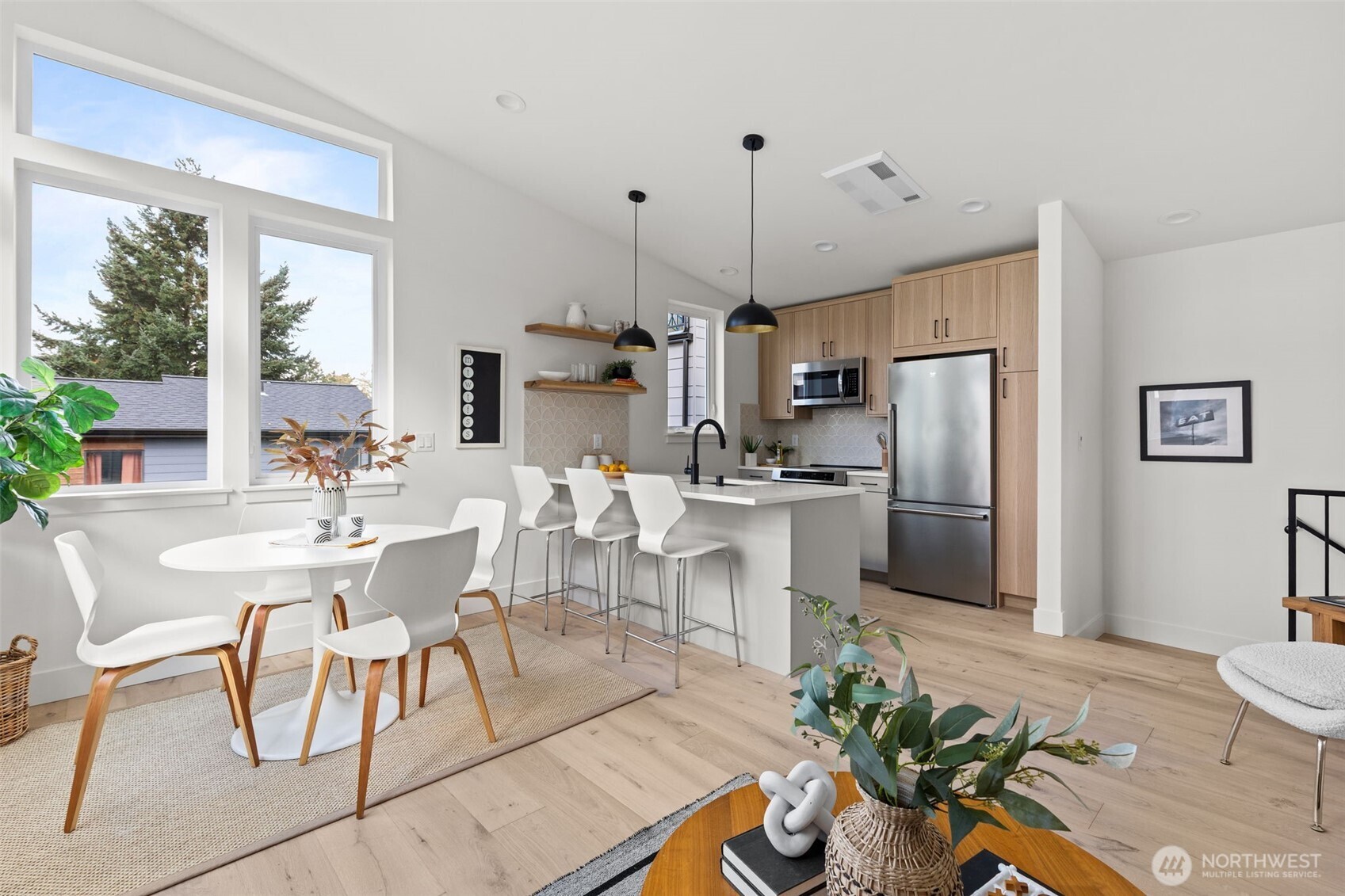 8407 42nd Avenue Southwest Seattle, WA 98136 - Photo 8 of 34 a kitchen with stainless steel appliances a dining table chairs a sink and dishwasher a refrigerator with wooden floor