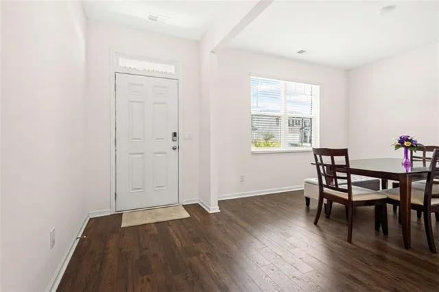 a view of a room with wooden floor lounge chair and windows