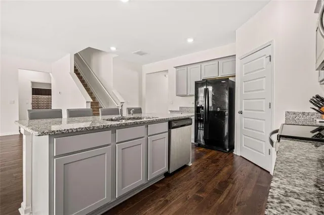 a kitchen with stainless steel appliances granite countertop a refrigerator and a stove