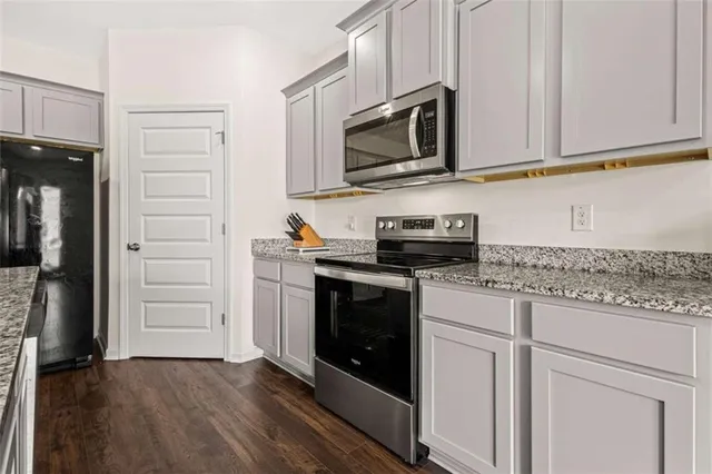 a kitchen with stainless steel appliances granite countertop a stove a microwave and a refrigerator