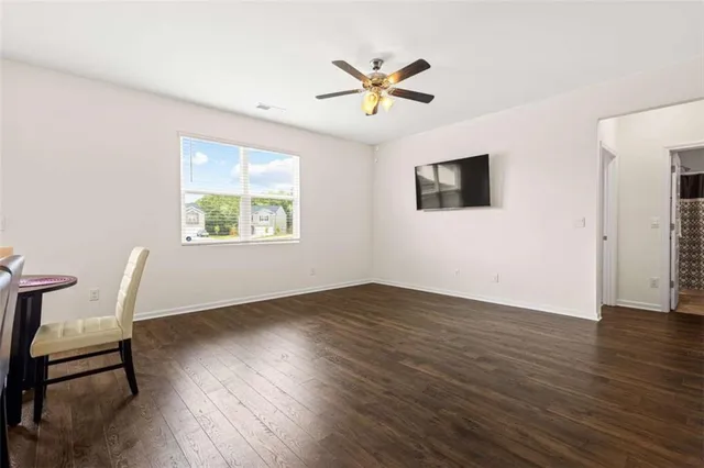 a view of a livingroom with a window and wooden floor