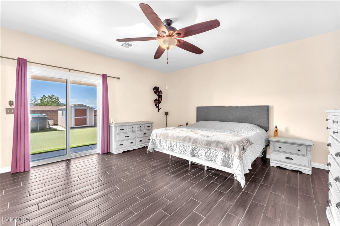 2251 Thoroughbred Road Henderson, NV 89002 - Photo 28 of 60 Bedroom with dark wood-style flooring, visible vents, access to exterior, and baseboards