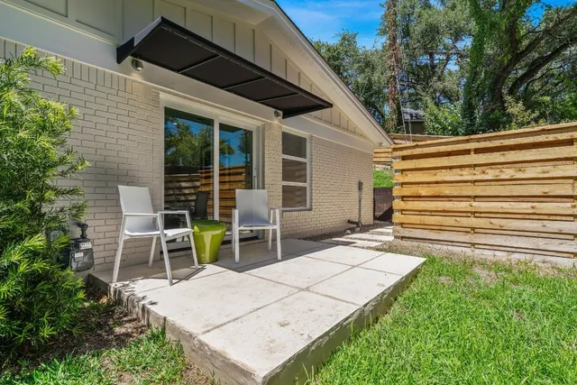 an aerial view of residential houses with outdoor space and trees