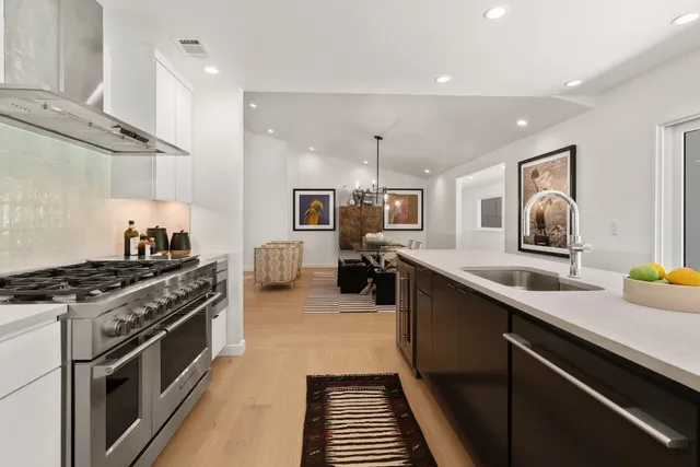 a kitchen with stainless steel appliances a sink stove and cabinets