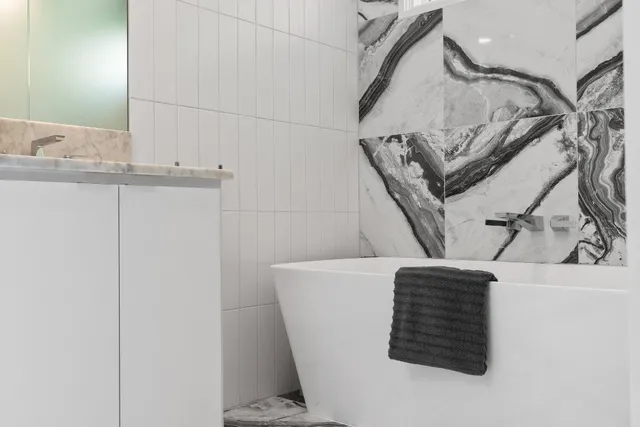 a bathroom with a granite countertop sink a mirror a vanity and a shower