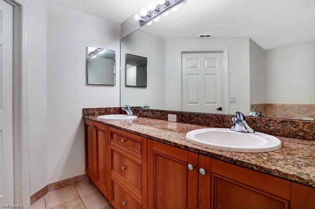 a bathroom with a double vanity sink and a mirror