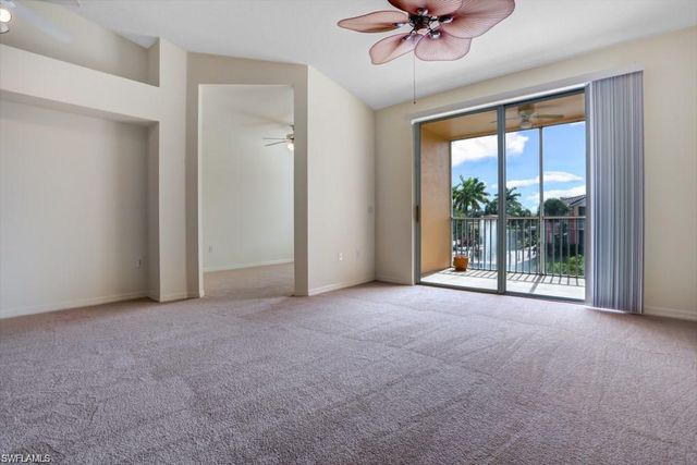 a view of a room with a ceiling fan and a floor to ceiling window
