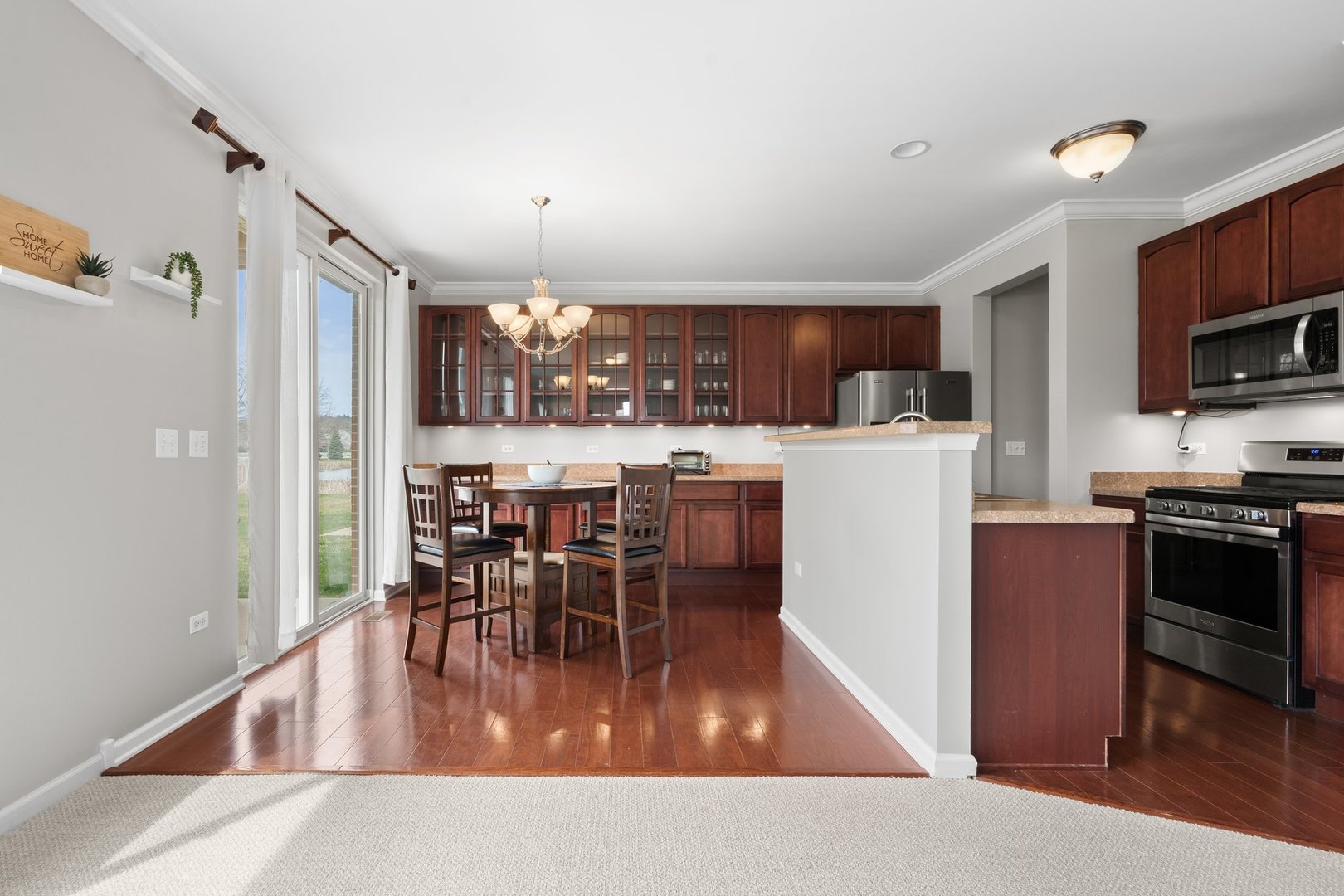 1116 Draper Road, Unit 1116 McHenry, IL 60050 - Photo 6 of 20 a kitchen with stainless steel appliances granite countertop a refrigerator a stove top oven a sink dishwasher a dining table and chairs with wooden floor