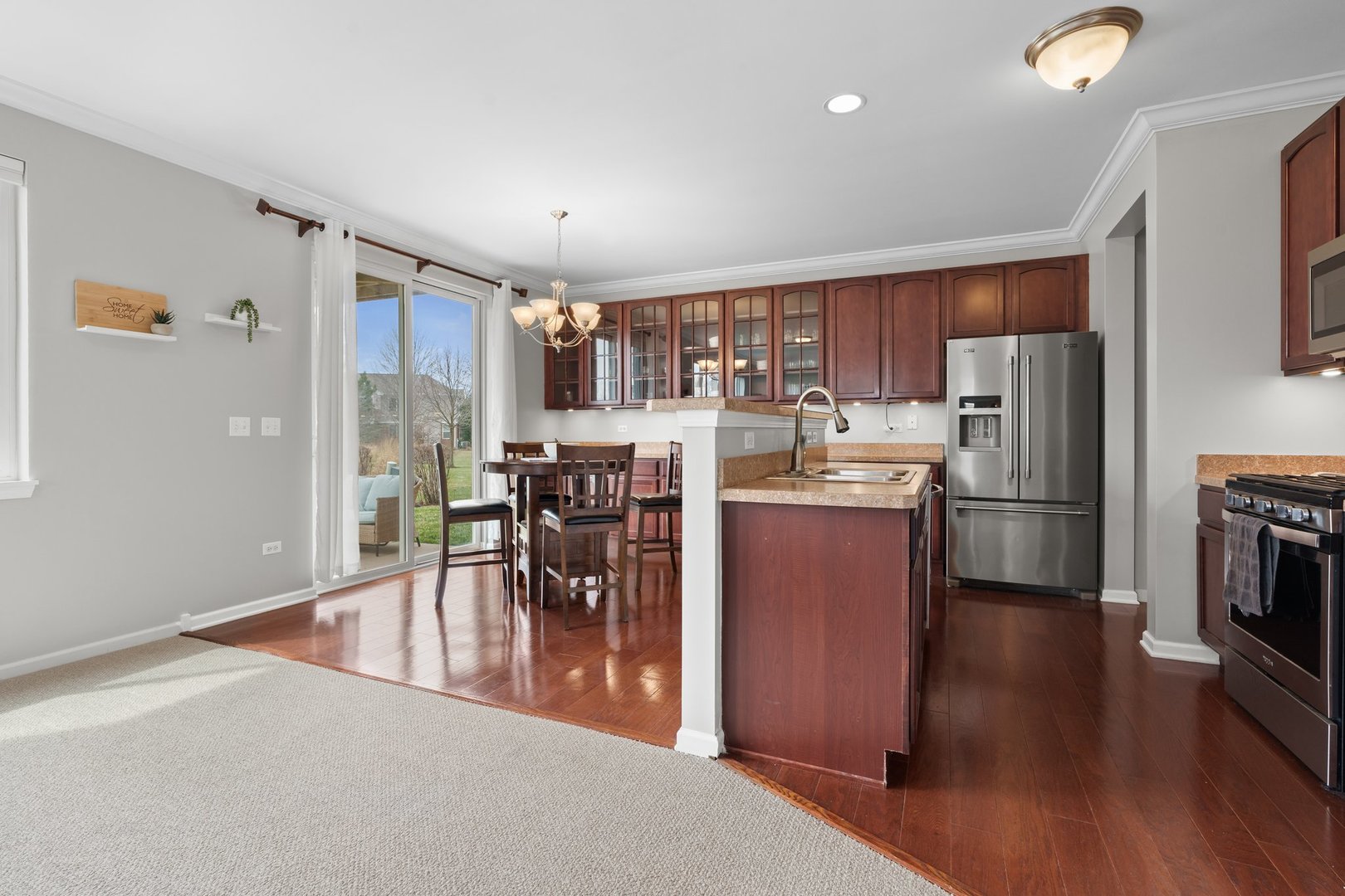 1116 Draper Road, Unit 1116 McHenry, IL 60050 - Photo 10 of 20 a kitchen with stainless steel appliances a dining table chairs stove refrigerator and cabinets