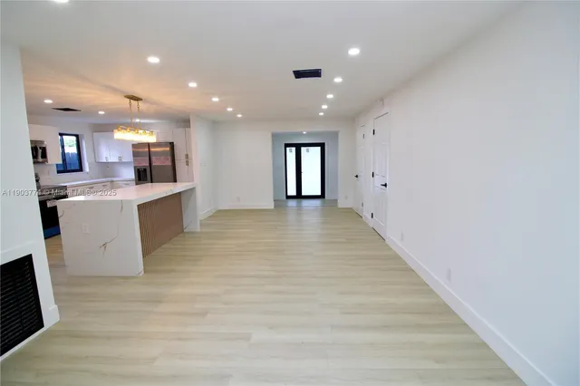 a view of kitchen with kitchen island and stainless steel appliances