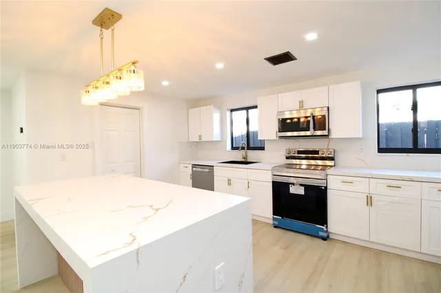 a kitchen with stainless steel appliances and white cabinets