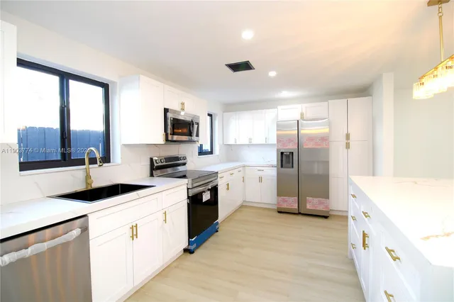 a kitchen with a sink a stove a refrigerator a window and a kitchen island