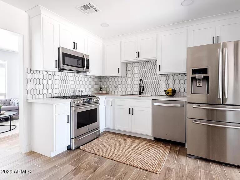2915 West Griswold Road Phoenix, AZ 85051 - Photo 6 of 17 a kitchen with white cabinets stainless steel appliances and sink