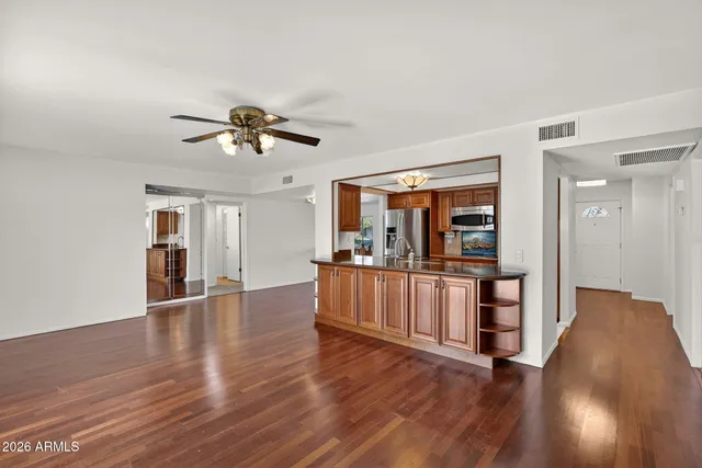 a view of an empty room with window and wooden floor