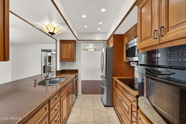 a kitchen with granite countertop a sink stove and refrigerator