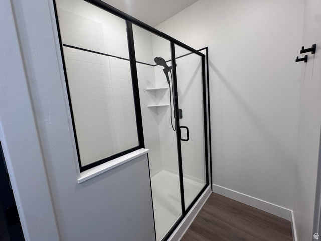 1301 1475 East, Unit 33 Payson, UT 84651 - Photo 9 of 10 Enclosed shower with matte black framing and hardware, white subway tile surround, integrated corner shelving, and a dark wood-finish flooring