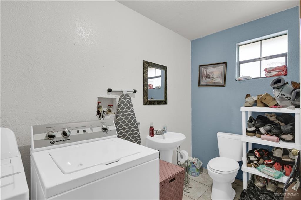 309 Domingo Navarez Street Rio Grande City, TX 78582 - Photo 11 of 14 Half bathroom with light tile patterned floors and independent washer and dryer