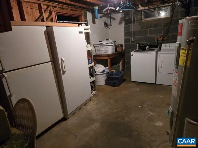 a view of storage and utility room with refrigerator and washer