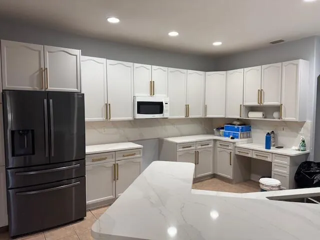 a kitchen with white cabinets and stainless steel appliances