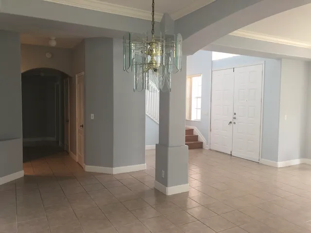 a view of a hallway with chandelier and entryway