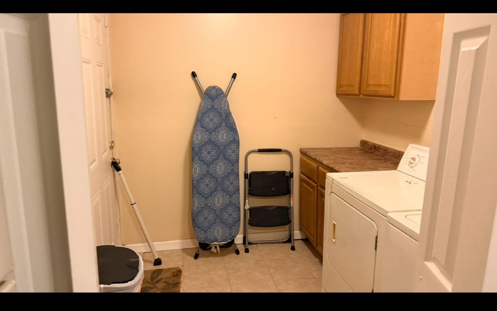 476 Jenson Road Memphis, TN 38109 - Photo 8 of 17 Laundry area with cabinet space, light tile patterned flooring, and washer and clothes dryer