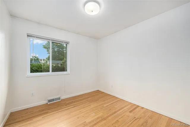 a view of an empty room with wooden floor