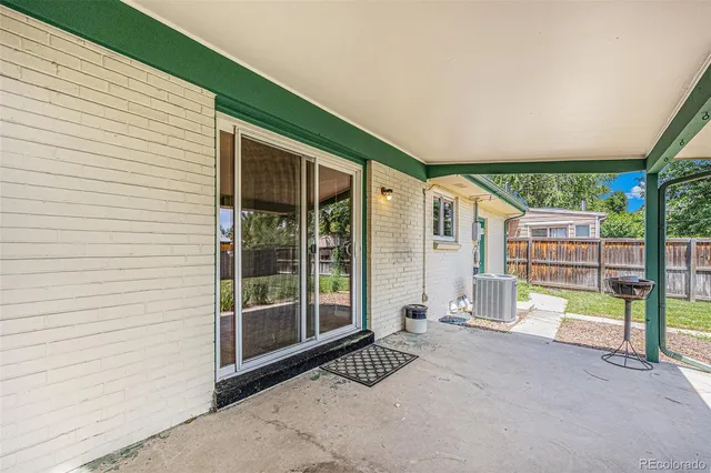 a view of a backyard with table and chairs and wooden fence