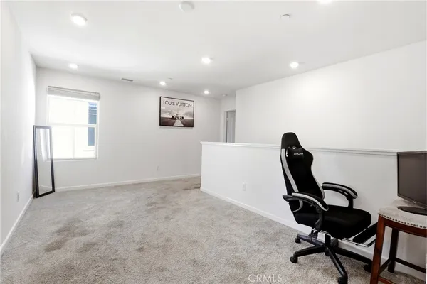 a view of a workspace with furniture and a window