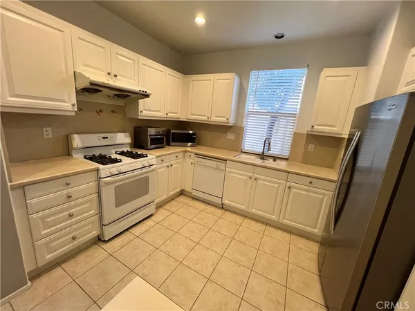 a kitchen with white cabinets and white appliances
