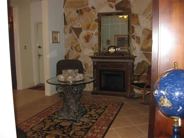 a living room with fireplace furniture and books on a table