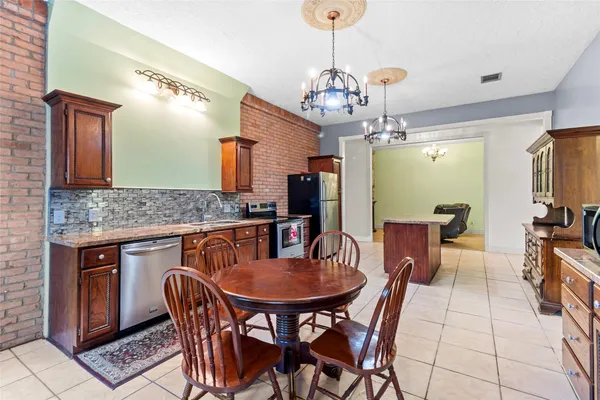a kitchen with stainless steel appliances granite countertop a stove refrigerator and cabinets
