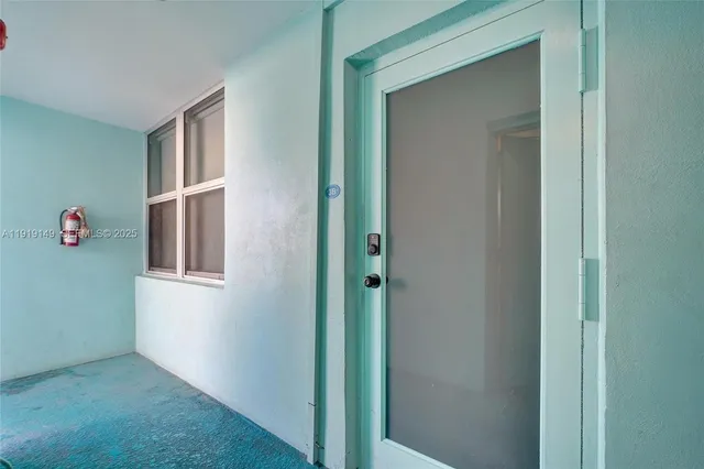 a view of kitchen with granite countertop cabinets and refrigerator