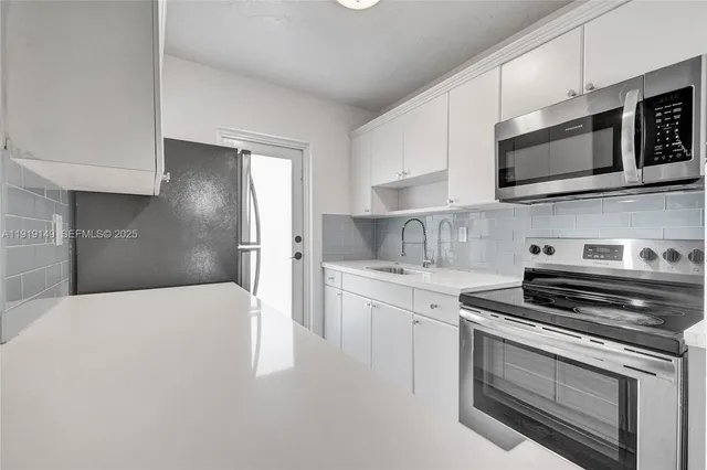 a kitchen with white cabinets and white appliances