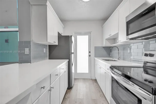 a kitchen with stainless steel appliances granite countertop a sink and a refrigerator