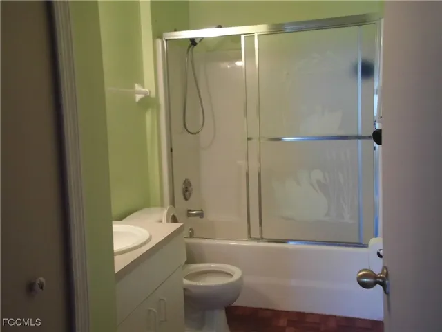 a bathroom with a granite countertop bathtub shower sink vanity and toilet
