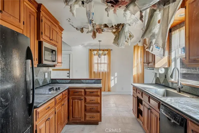 a kitchen with stainless steel appliances granite countertop a refrigerator a stove and a microwave oven