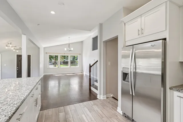 a view of a kitchen with wooden floor and a refrigerator