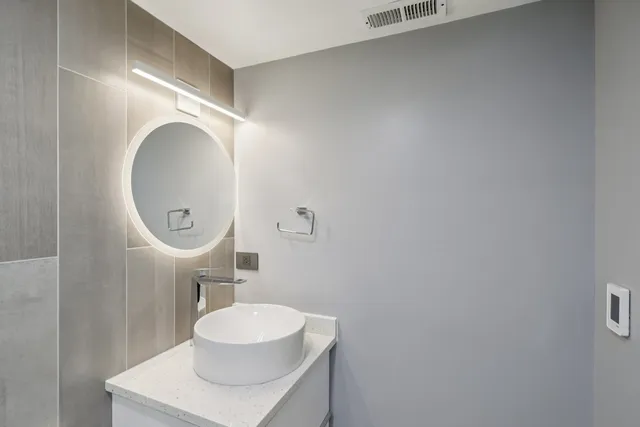a bathroom with a sink mirror and toilet
