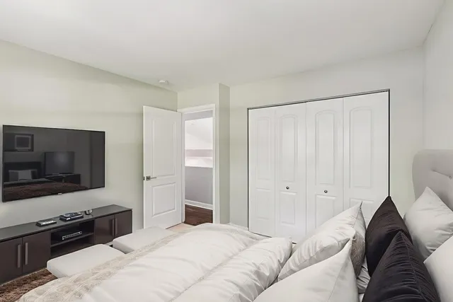 a bedroom with a bed and a flat screen tv